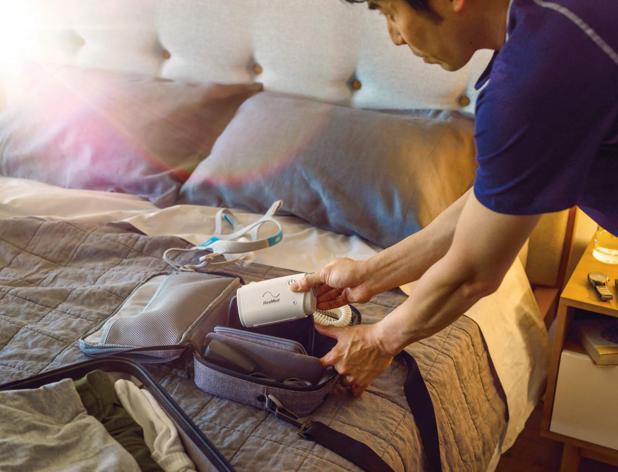 A man packing his AirMini in an overnight bag in preparation for a trip away.