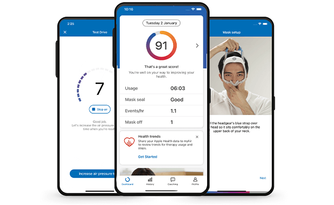 En søvnapnépasient sitter ved AirCurve 11-apparatet sitt og holder en mobil med myAir-appen på.